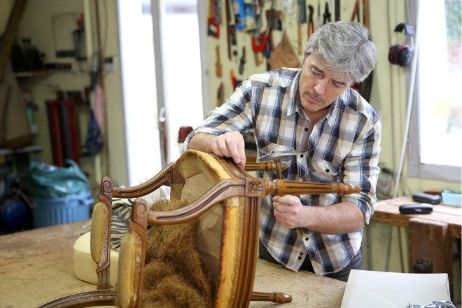 Man restoring antique timber chair